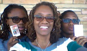 A mother takes a selfie of her and her two children as they celebrate getting their new ID cards.