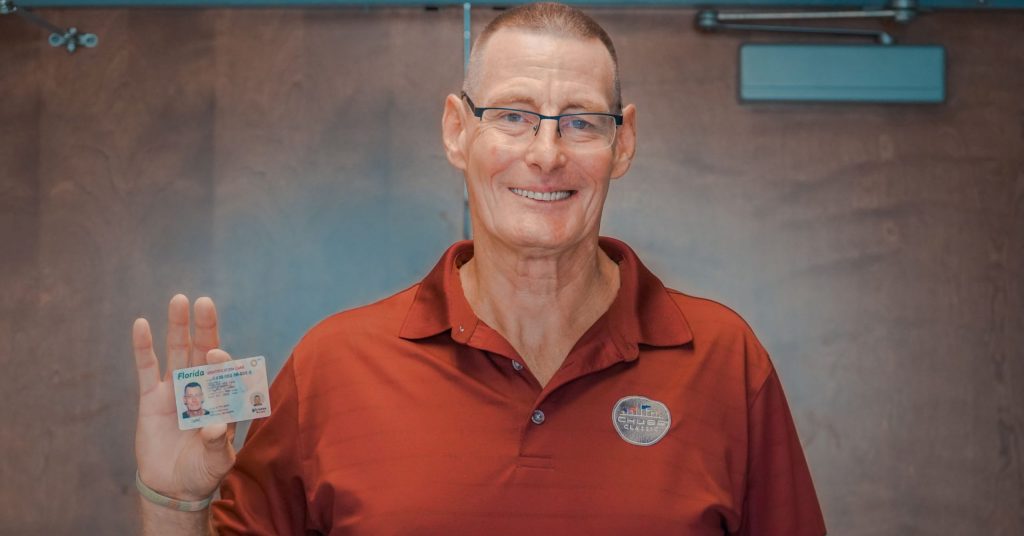 Client Chris shows off the ID that changed his life