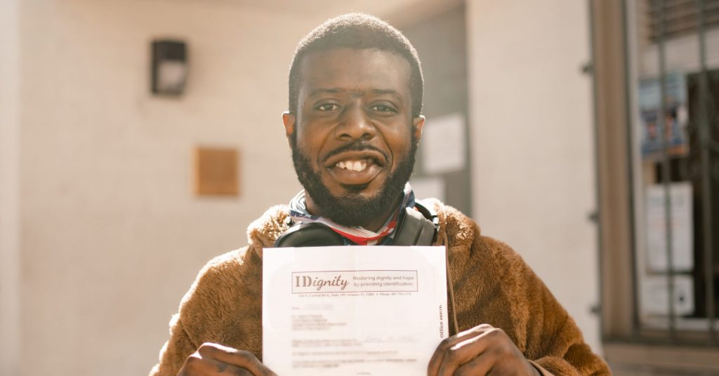 IDignity client Benny holds up the voucher that will help him get his Florida birth certificate.